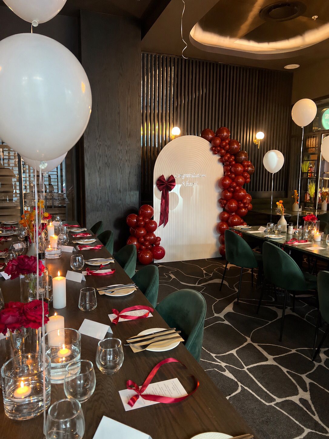 Red balloon arch with dining table setup