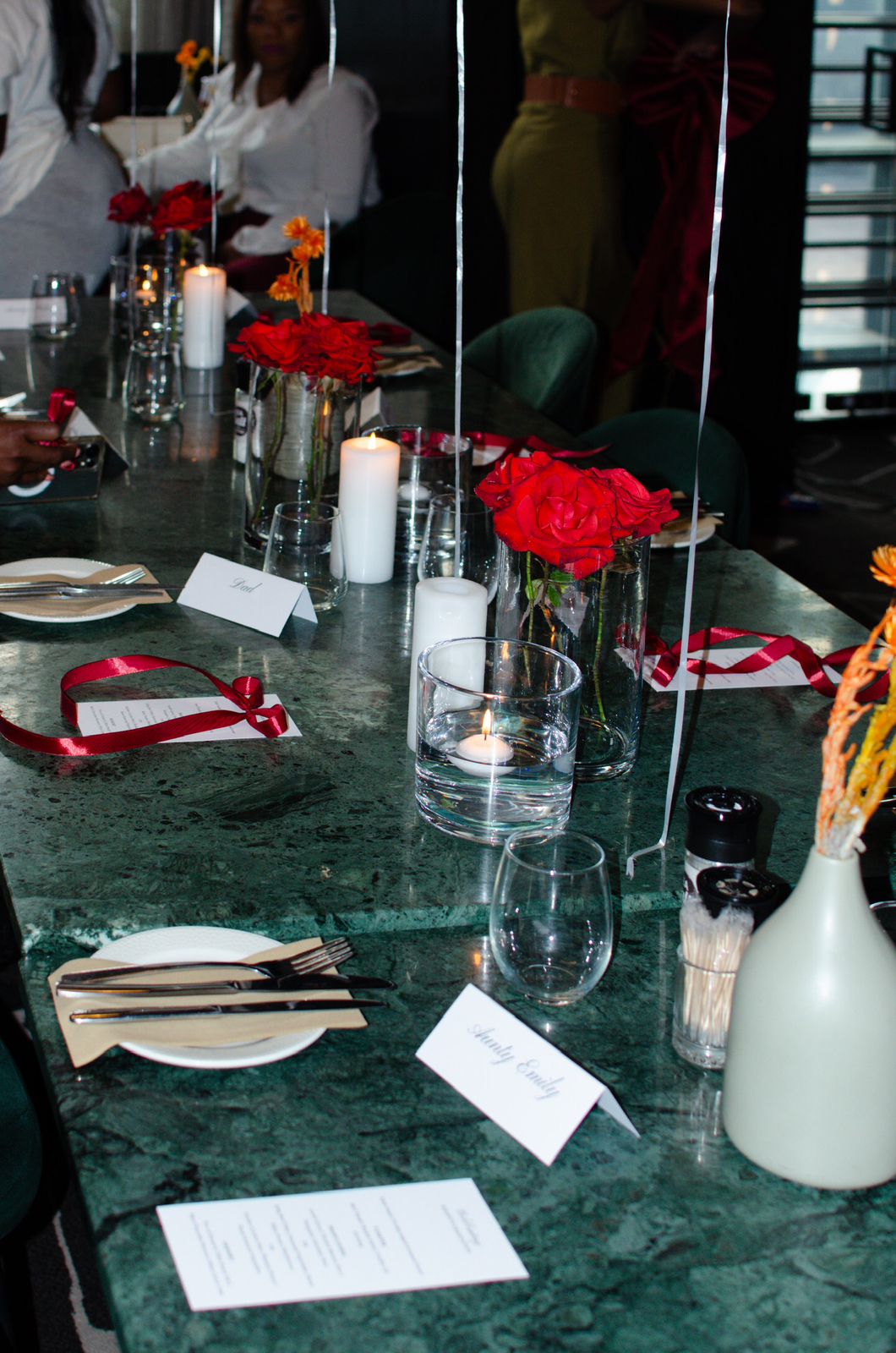 Green marble table with red roses and candles