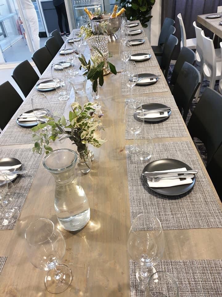Long dining table setup with dark plates